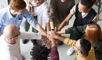 A circle of people with their hands stacked on top of one another