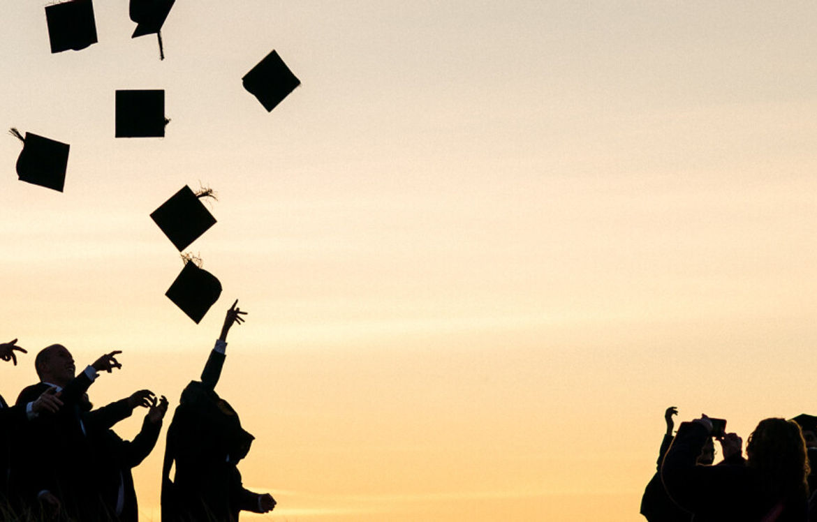 Graduates throwing their hats into the air