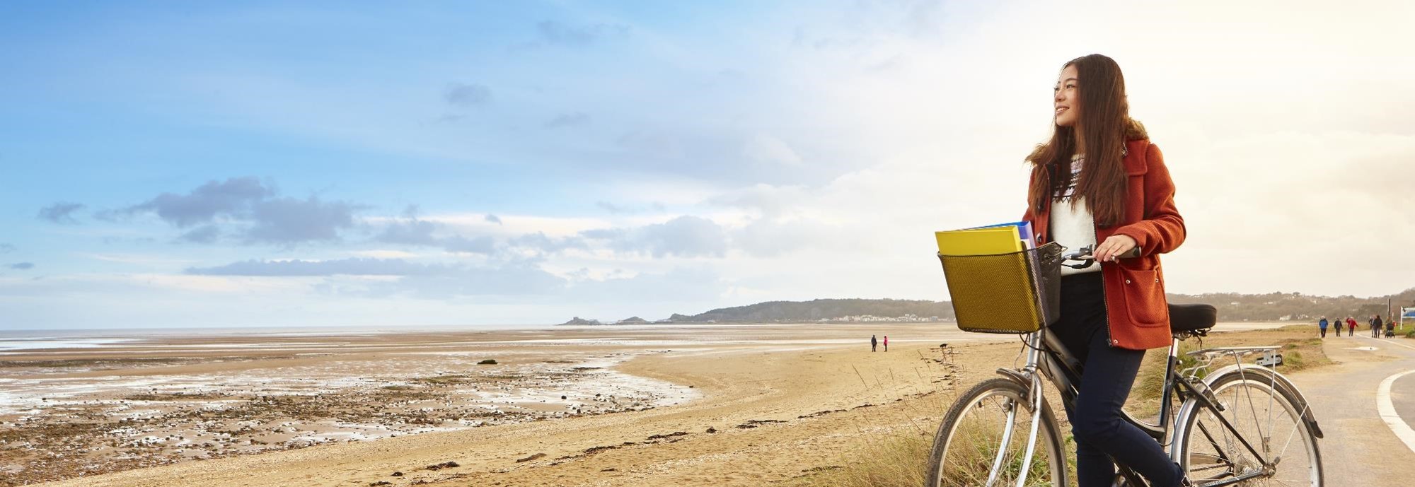 Chinese student on bike looking out to sea