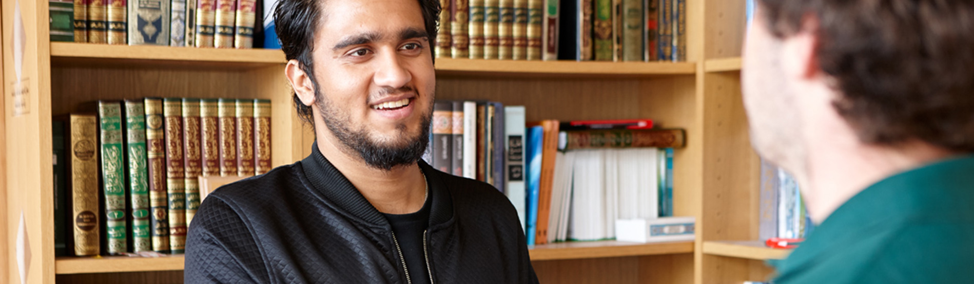 Student with library books behind him.