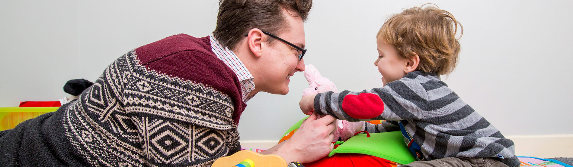 Student interacting in play with a young child.