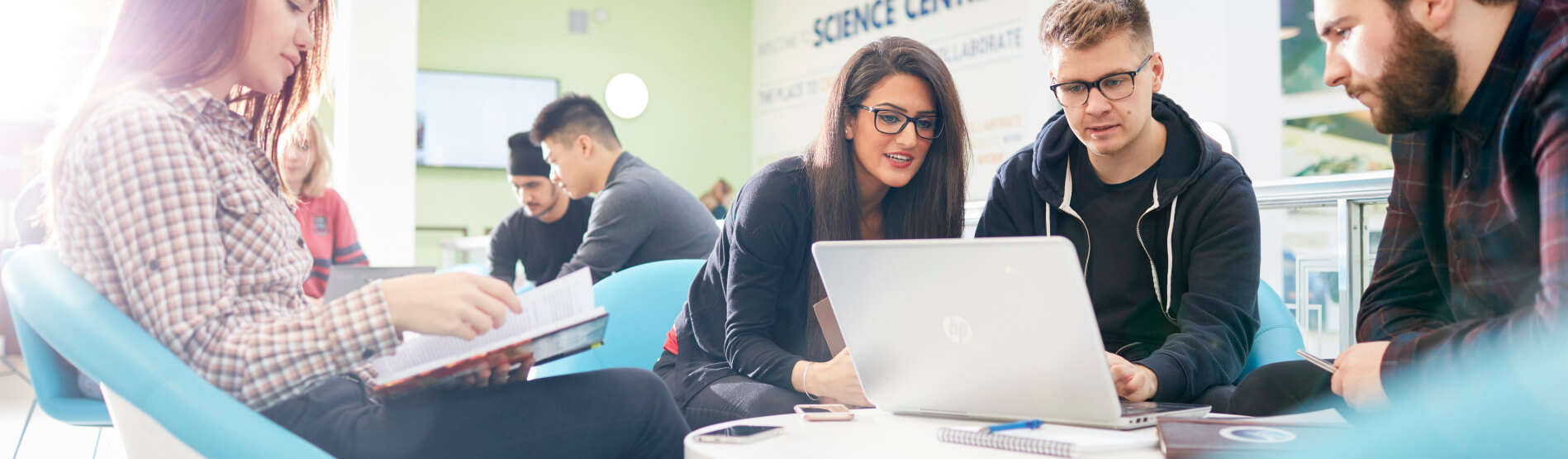 Students sitting around a computer socialising