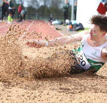 A long-jumper landing in sand