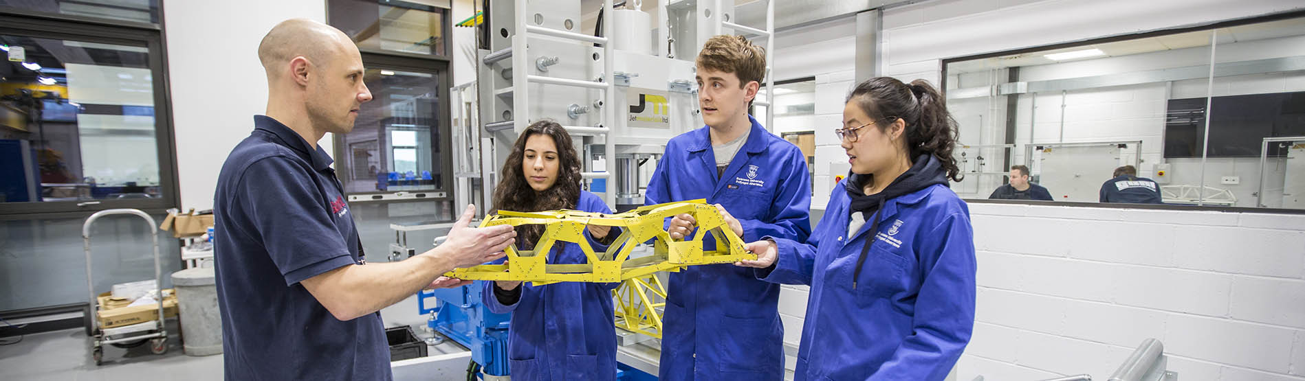 students discussing bridge in structures lab