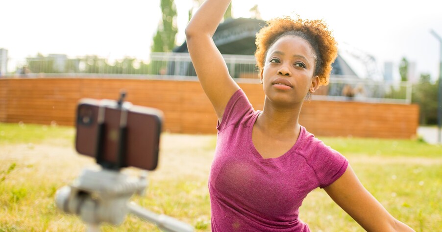 Student filming someone taking part in sport activity 