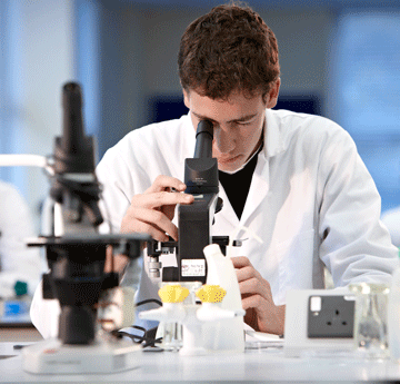 Student looking through microscope in a lab