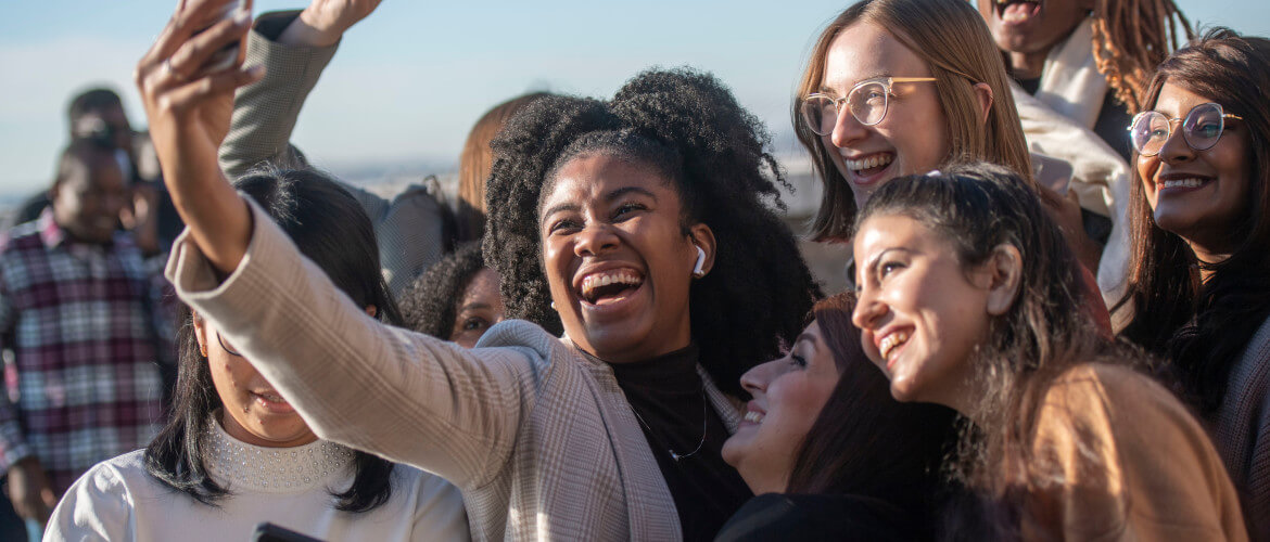 Students taking a selfie by the beach on Bay Campus