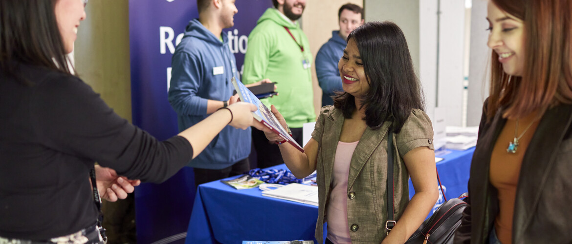 Student speaking to an exhibitor at an event