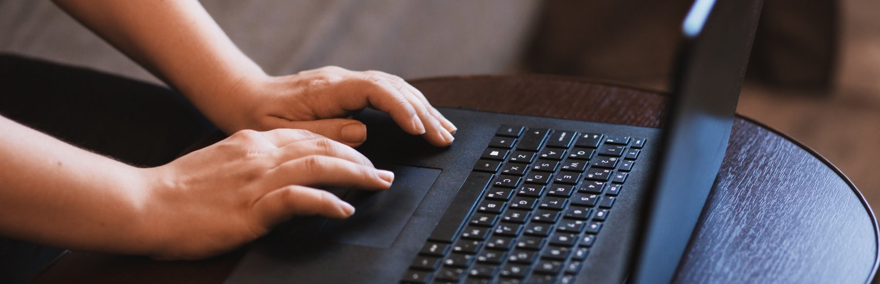 Hands typing on a laptop keyboard